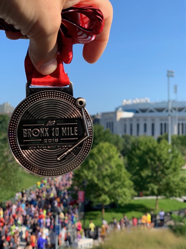Bronx 10 Mile race medal in front of Yankee Stadium